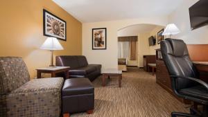 Habitación de hotel con sofá y silla en Best Western Executive Inn & Suites, en Colorado Springs