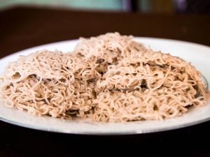 un mucchio di spaghetti su un piatto su un tavolo di Sunstyle Mirissa Guest House a Mirissa