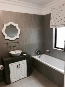 a bathroom with a sink and a bath tub at At Home in Mostertsdrift in Stellenbosch