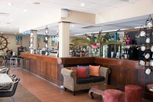 a bar in a restaurant with chairs and a counter at Roebuck Bay Hotel in Broome