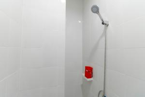 a shower with a shower head in a bathroom at RedDoorz Plus @ Kapuk Business Park in Jakarta +18 photos