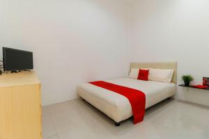 a bedroom with a bed and a television in it at RedDoorz Plus @ Kapuk Business Park in Jakarta