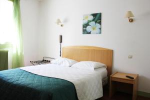 Un pat sau paturi într-o cameră la Hotel Le Chapitre