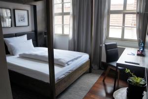 a bedroom with a bed and a desk and window at Ebracher Hof in Schweinfurt