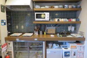 a kitchen with a sink and a microwave at Guest House Nakaima in Fukuoka