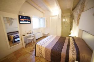 a bedroom with a bed and a desk and a window at Il Belvedere in Matera