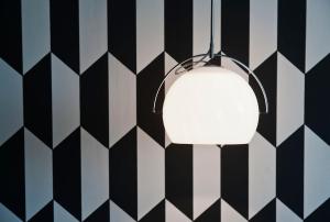 a white lamp hanging from a black and white wall at Hôtel Emile Le Marais in Paris