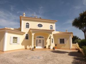 duży biały dom z palmą w obiekcie Villa Estrelamar w mieście Boliqueime