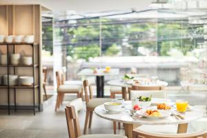 曼谷的住宿－克利泰套房酒店，一间餐厅配有桌椅,提供食物