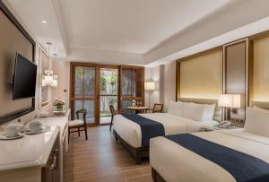 a hotel room with two beds and a desk at Henann Crystal Sands Resort in Boracay +14 photos