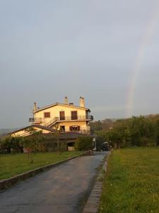 a house on a road with a rainbow in the background at Around Rome in Marino