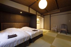 a bedroom with a large bed and a chair at Yufuin Souan Kosumosu in Yufu +124 photos