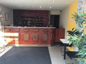 uma sala de degustação com um bar de madeira com garrafas de vinho em Solar Club Hotel em Sopron