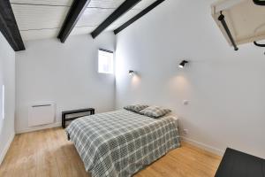 オンフルールにあるLe loft de Cathy 1の白い壁のベッドルーム1室、ベッド1台(毛布付)