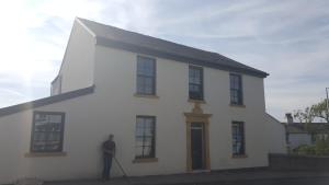 a man standing in front of a white house at Saracens House in Preesall
