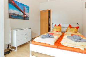 a bedroom with two beds with orange and yellow pillows at Ferienwohnung City in Erfurt