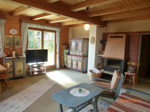 sala de estar con mesa y chimenea en Almhaus Hochrindl, en Hochrindl