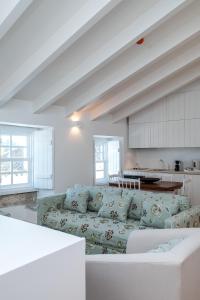 ein Wohnzimmer mit einem Sofa und einer Küche in der Unterkunft Lugares Com História in Óbidos