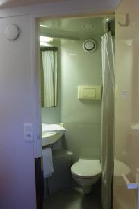 a small bathroom with a toilet and a sink at Premiere Classe St Brieuc Tregueux in Tregueux