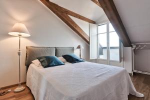 トリノにあるMansarda in Borgo Poのベッドルーム(青い枕の大きな白いベッド付)