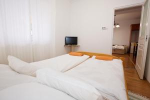 ハイドゥソボスローにあるZoli Apartmanok-Anita Kölcsey 34-36のベッドルーム(白いベッド2台、テレビ付)