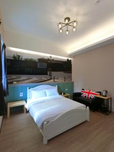 花蓮市にあるTen Minute To Go B&Bの大きな白いベッドとシャンデリアのある寝室