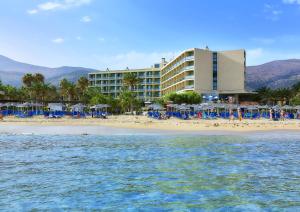 ein Hotel am Strand mit Liegestühlen und Sonnenschirmen in der Unterkunft Sirens Beach & Village in Malia