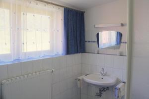 Baño blanco con lavabo y espejo en Am Zanggerhof, en Imst