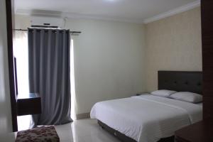 a bedroom with a white bed and a window at MTC Mega Mas Apartment in Manado