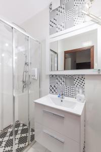 y baño blanco con lavabo y ducha. en Hotel-24, en Płock