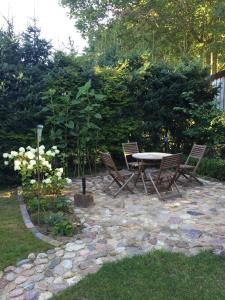 een patio met een tafel en stoelen in een tuin bij fewo anderswo in der Nähe von Stralsund in Pantelitz