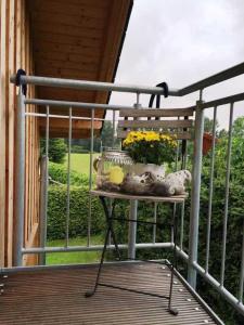 a table on a porch with birds and flowers on it at fewo anderswo in der Nähe von Stralsund in Pantelitz