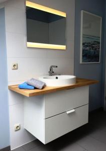 een badkamer met een wastafel en een spiegel bij fewo anderswo in der Nähe von Stralsund in Pantelitz