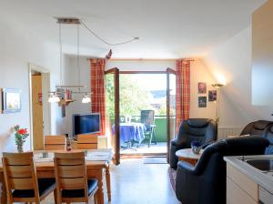 een woonkamer met een tafel en stoelen en een televisie bij Apartmenthaus Hansen in Büsum