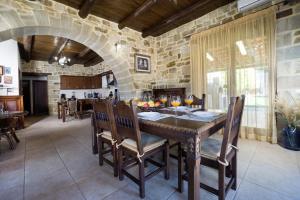 uma sala de jantar com uma mesa e uma parede de pedra em Villa Platanos em Plátanos