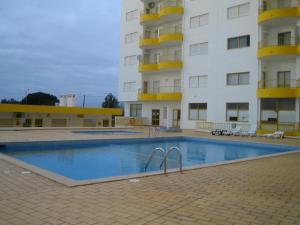 a large swimming pool in front of a building at O Presidente in Portimão