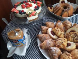 a table topped with plates of pastries and a cake at Hotel At the Golden Scissors in Prague