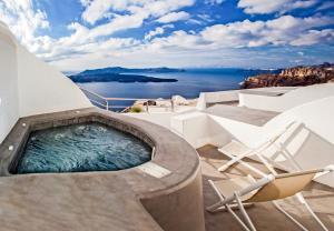 bañera de hidromasaje con sillas y vistas al océano en Villa Irini Fira - Adults Only, en Fira