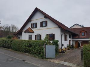 uma casa branca com um telhado castanho em Ferienwohnung Schütz em Hirschaid