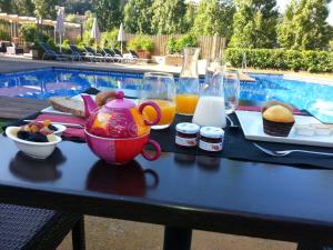 un tavolo con vassoio di cibo, teiera e succo di frutta di Hostalet de Begur - Adults Only a Begur
