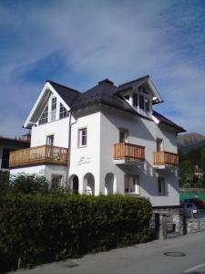 een wit huis met een zwart dak en een balkon bij Chalet Embacher by AlpenTravel in Bad Gastein
