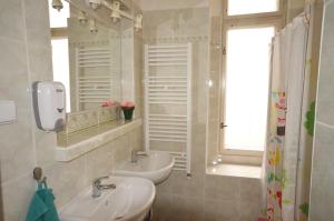 a bathroom with two sinks and a mirror and a window at Travel&Joy backpackers in Prague