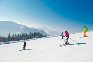 a group of people skiing down a snow covered slope at Ferienwohnung Gimplbauer in Faistenau