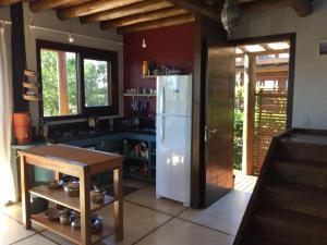 a kitchen with a white refrigerator and a table at Casa Linda e Aconchegante in Imbituba