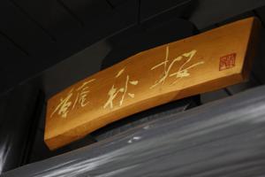 un panneau en bois avec des écrits chinois sur celui-ci dans l'établissement Yufuin Souan Kosumosu, à Yufu