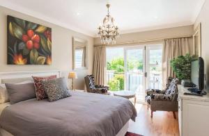 a bedroom with a large bed and a chandelier at Anna's Place in Cape Town