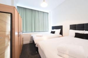 a hotel room with two beds and a window at Slps 14 Hot Tub, Bar & Outdoor Terrace in Manchester