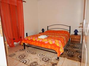 una camera con un letto e una coperta arancione di Small country apartment in Tripoli a Tripoli (Tripolis)