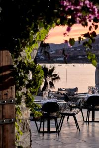 a table and chairs with a view of the beach at Poseidon of Paros Hotel & Spa in Chrissi Akti