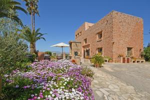 a brick building with flowers in front of it at Villa Torreon in Alcudia